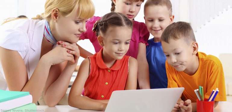 учительница с детьми смотрит на экран компьютера