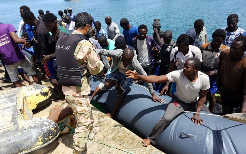 беженцы на берегу в лодках
